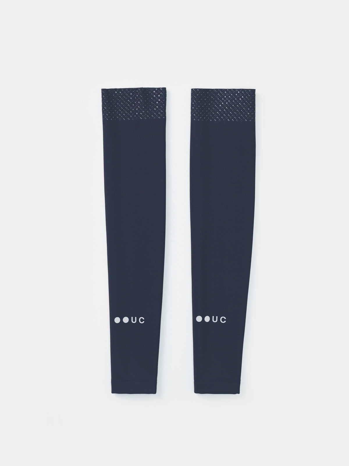 Flatlay of the Eclipse Navy Arm Warmers showing silicone UC-motif gripper band at the bicep and UC forearm wordmark.