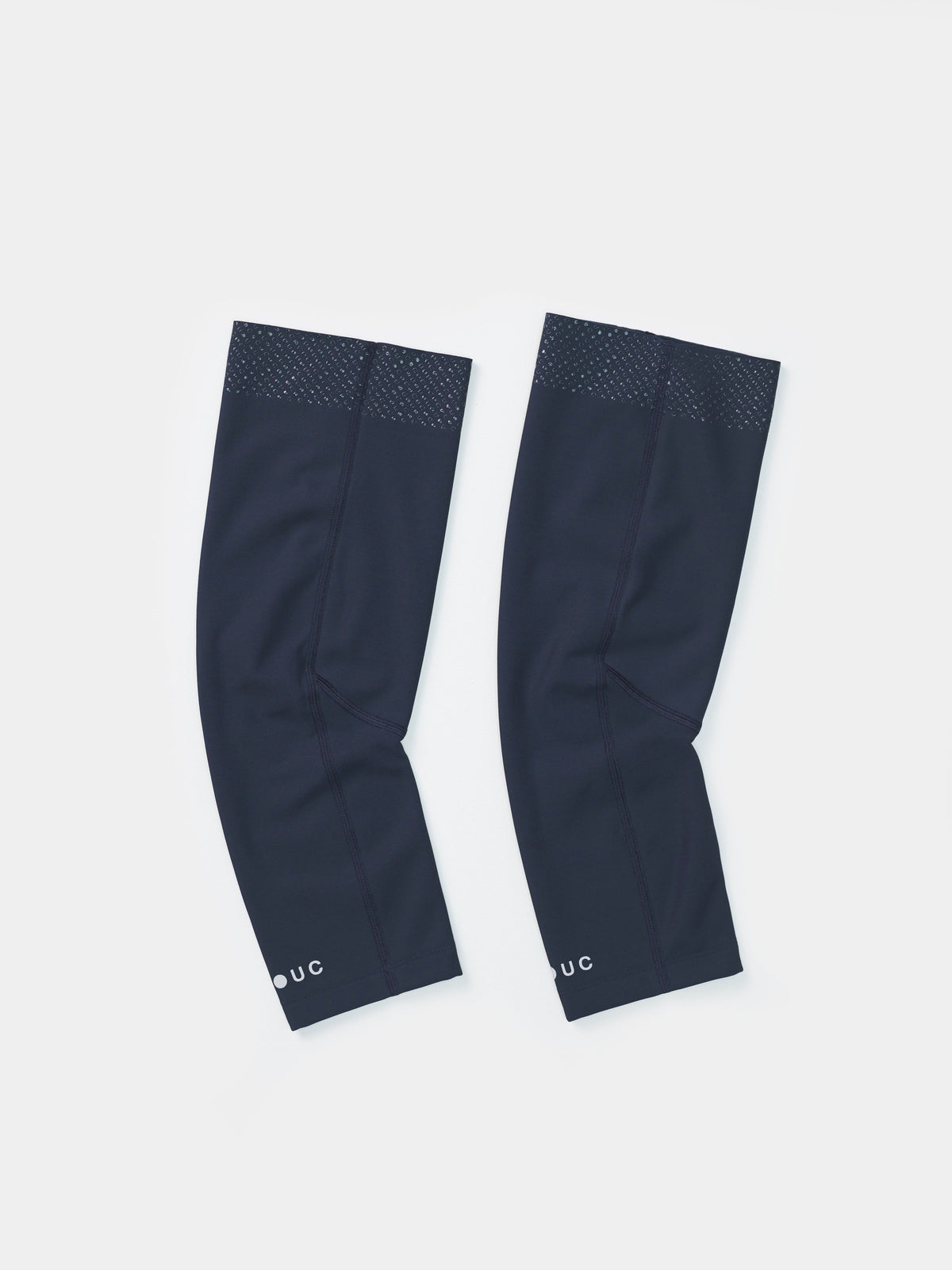 Flatlay of the Universal Colours Knee Warmers in Eclipse Navy, pair laid side by side showing silicone grip dot band at the thigh.