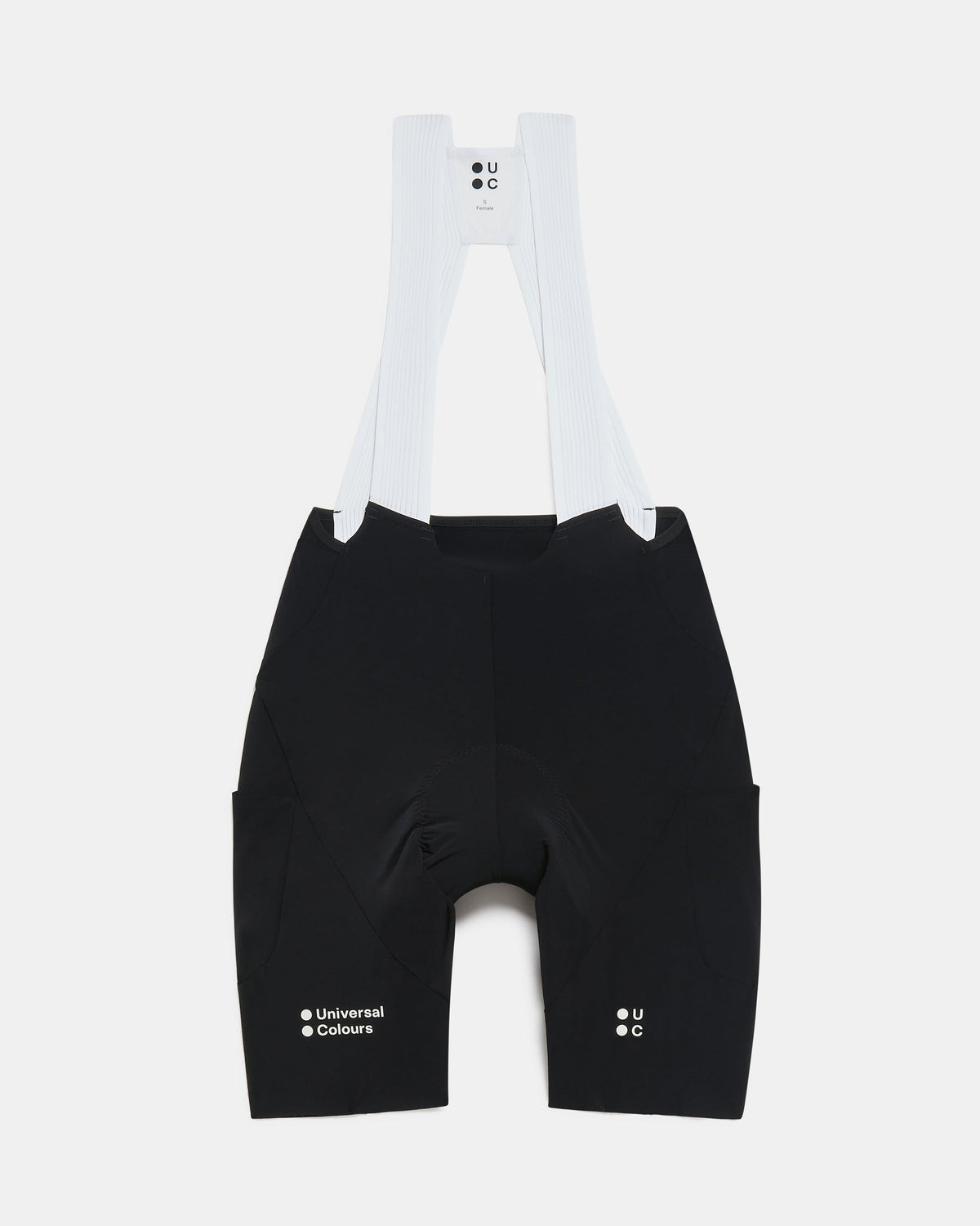 Flatlay of the Women's Chroma Cargo Bib Shorts in Black: ribbed bib straps, a pocket on each thigh and Universal Colours leg logos.