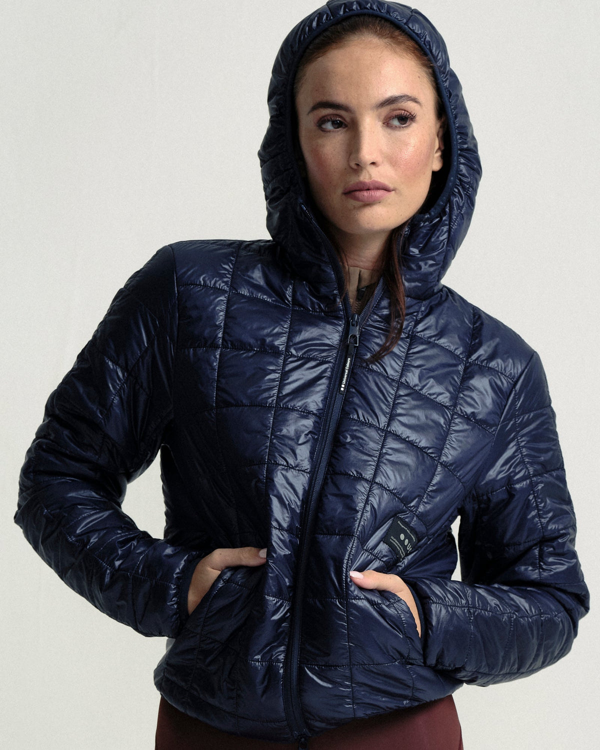 Model wearing the Unisex Insulated Packable Jacket in Ink Blue.