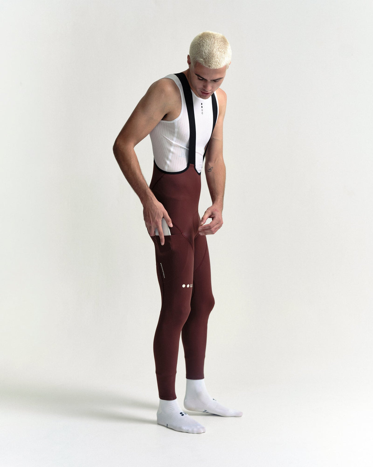 Model in the Men's Mono Cargo Bib Tight in Deep Red, full-length view.