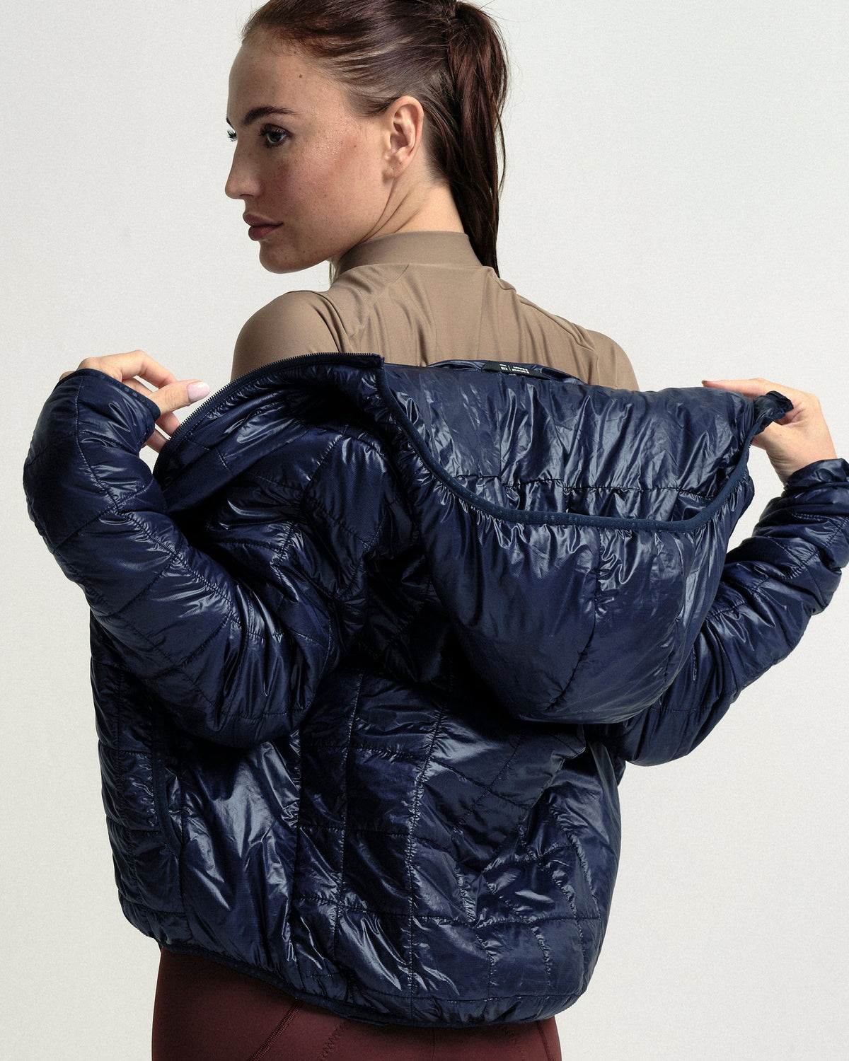 Model wearing the Unisex Insulated Packable Jacket in Ink Blue.