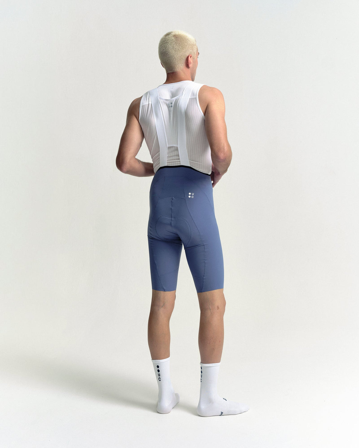 Model in the Men's Chroma Bib Shorts in Slate Blue, full-length back view.