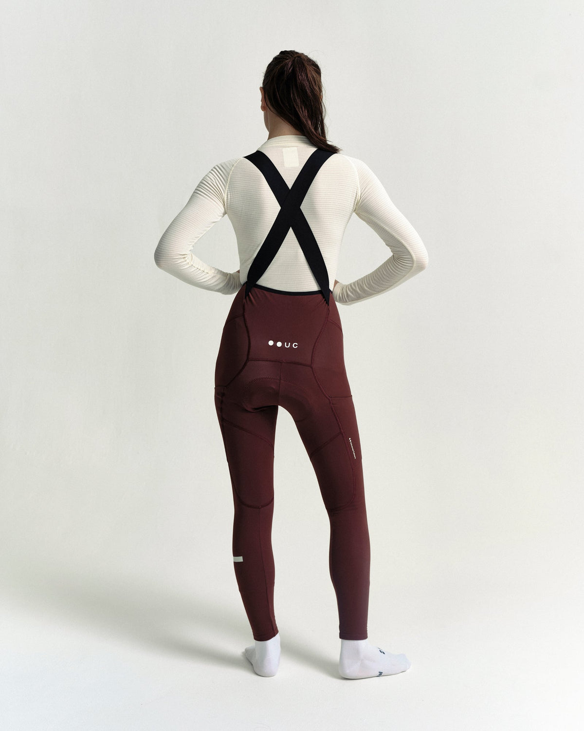 Model wearing the Women's Mono Cargo Bib Tight in Deep Red.