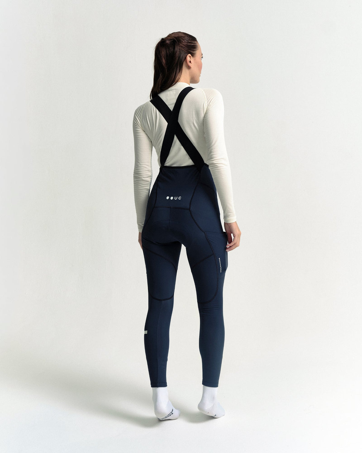 Model wearing the Women's Mono Cargo Bib Tight in Eclipse Navy.