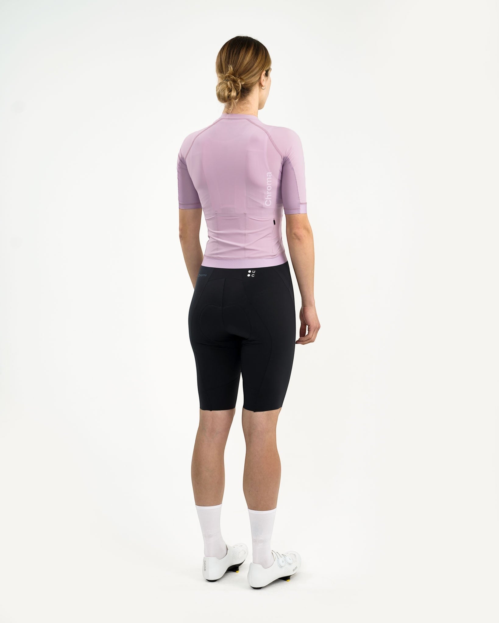 Moloko Cycling Ltd. women's washed lilac short sleeve cycling jersey with three rear pockets and a full-length zip, shown on a model wearing black cycling shorts.