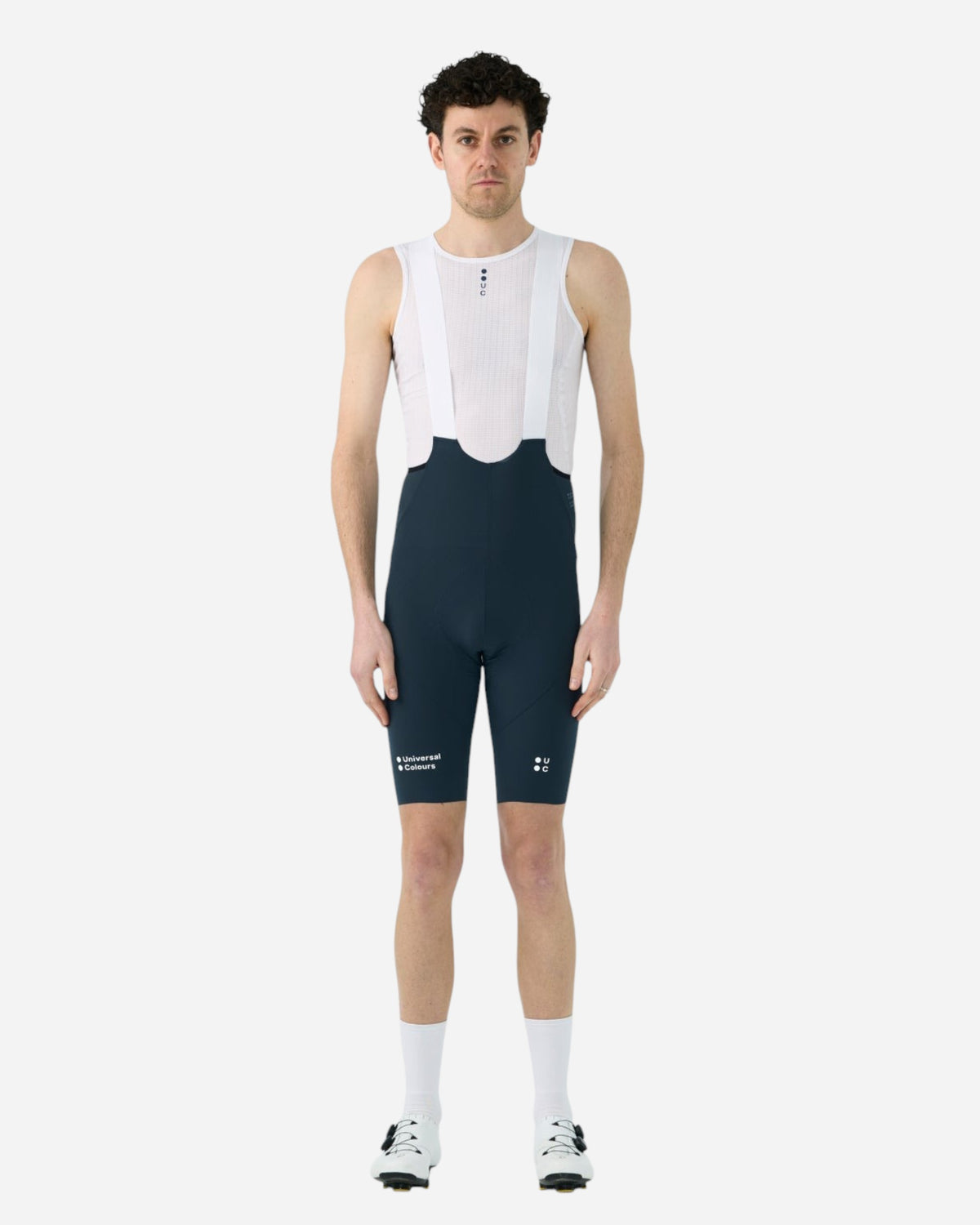 Male cyclist wearing Moloko Cycling Ltd. navy blue Chroma bib shorts with white breathable straps and performance pad