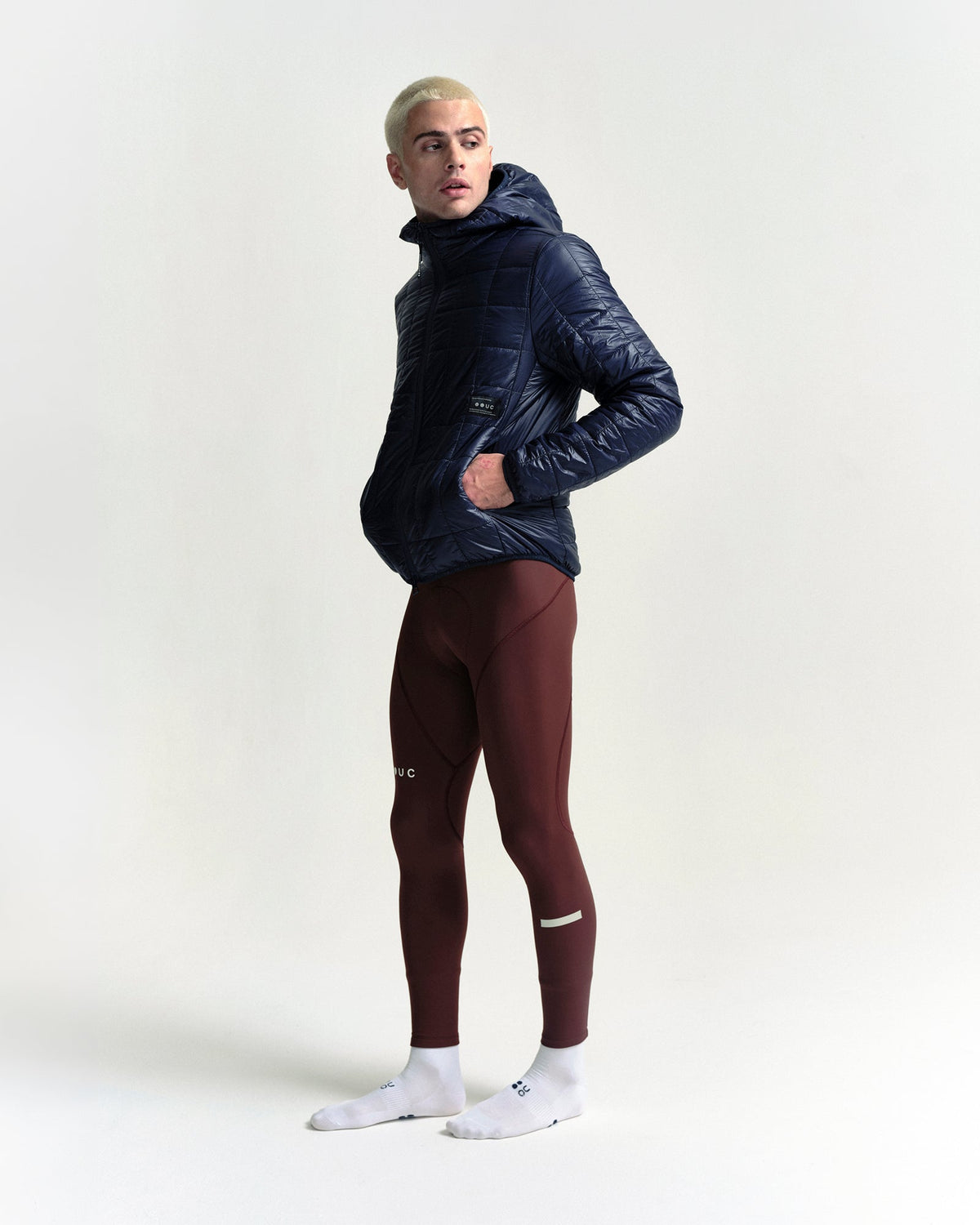 Model wearing the Unisex Insulated Packable Jacket in Ink Blue.