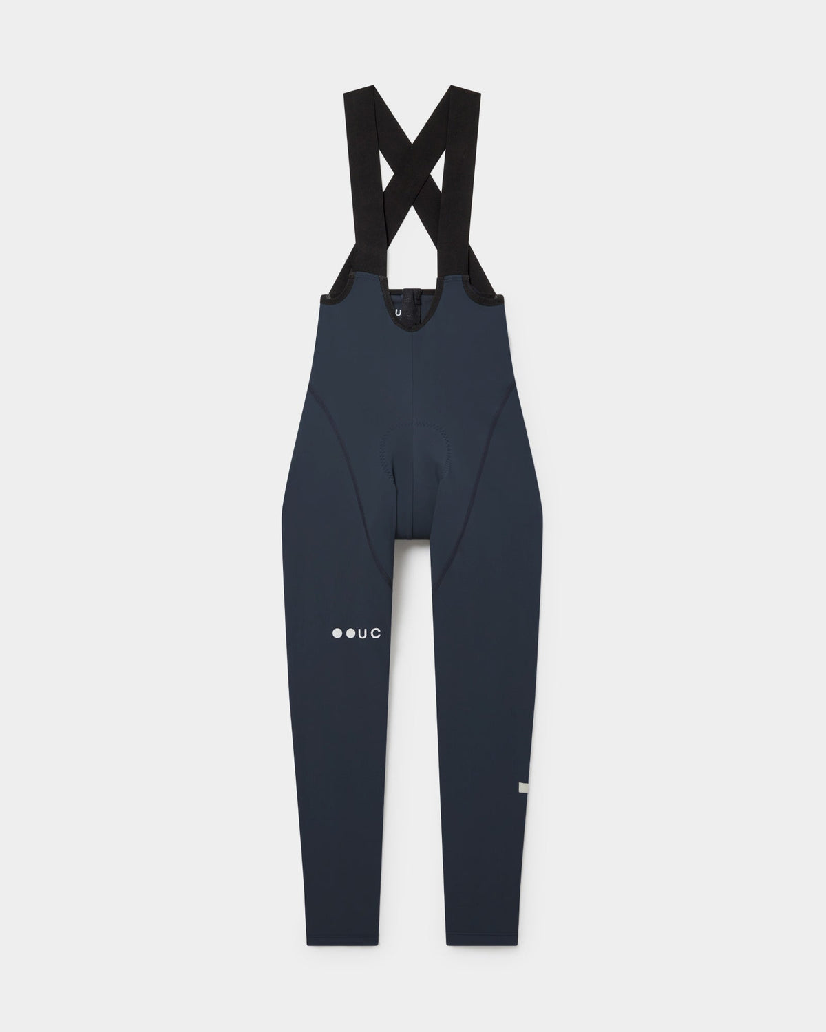 Flatlay of the Women's Mono Bib Tight in Eclipse Navy: crossed shoulder straps, integrated chamois and UC logo on the thigh.