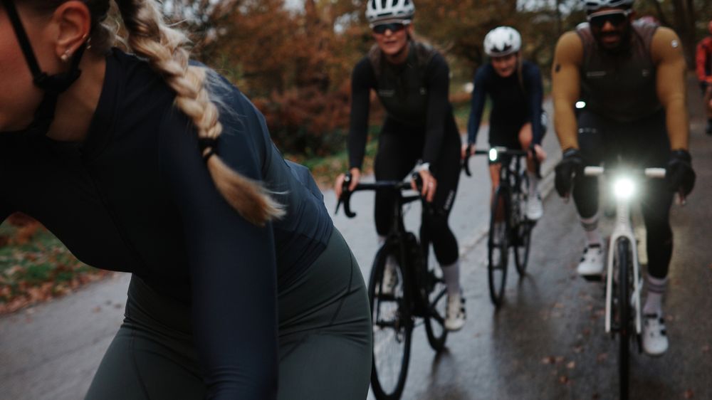 Riders coming towards the camera on a wet autumn park road, front lights on