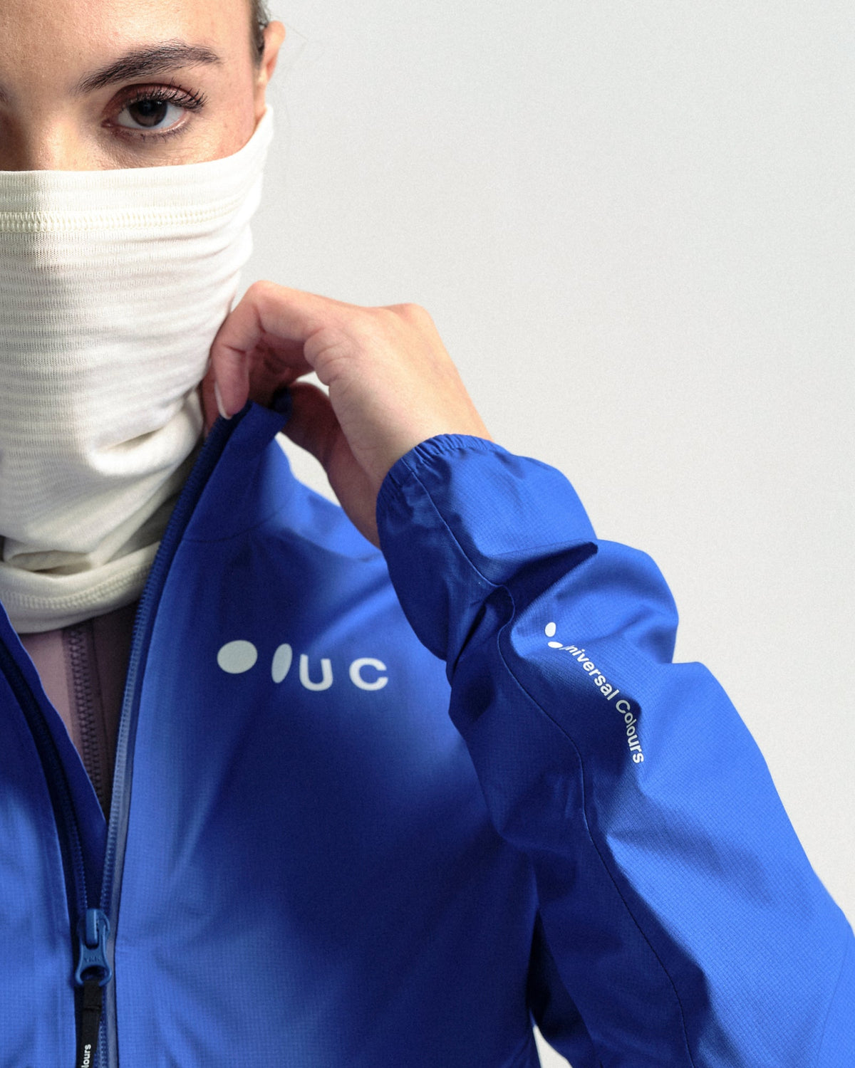 Model wearing the Polartec Neck Warmer in Off White.