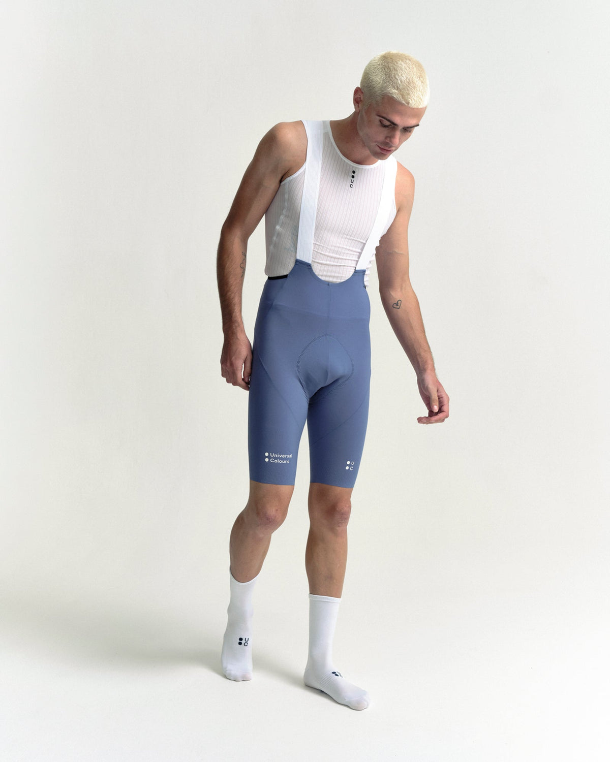 Model walking in the Men's Chroma Bib Shorts in Slate Blue, full-length view.