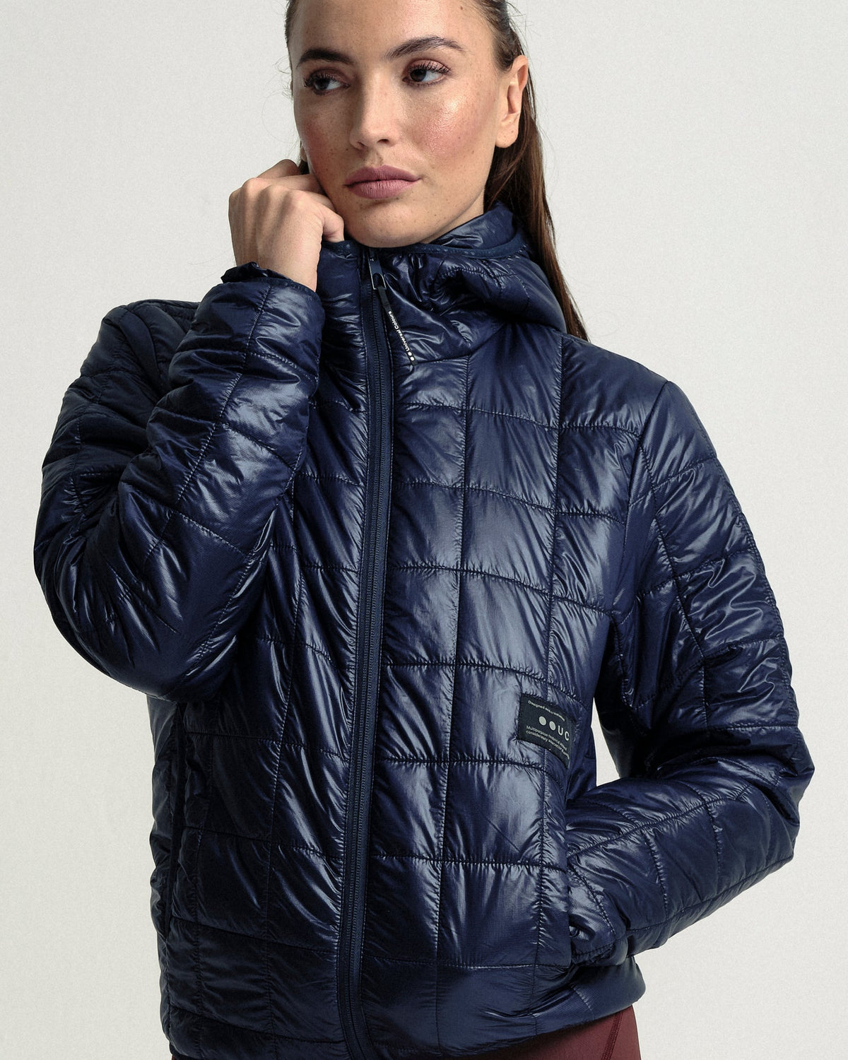Model wearing the Unisex Insulated Packable Jacket in Ink Blue.