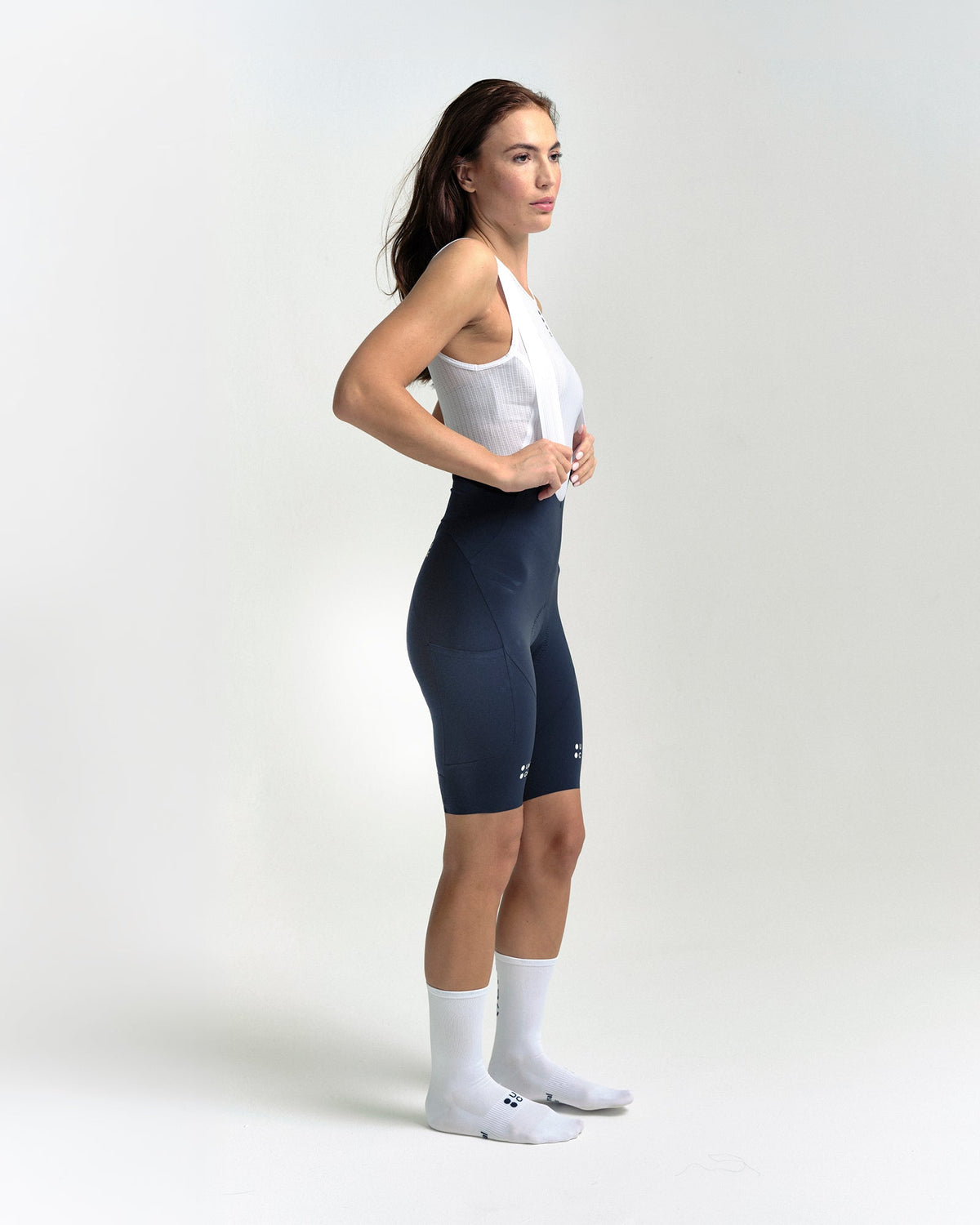 Model wearing the Women's Chroma Cargo Bib Shorts in Navy Blue.