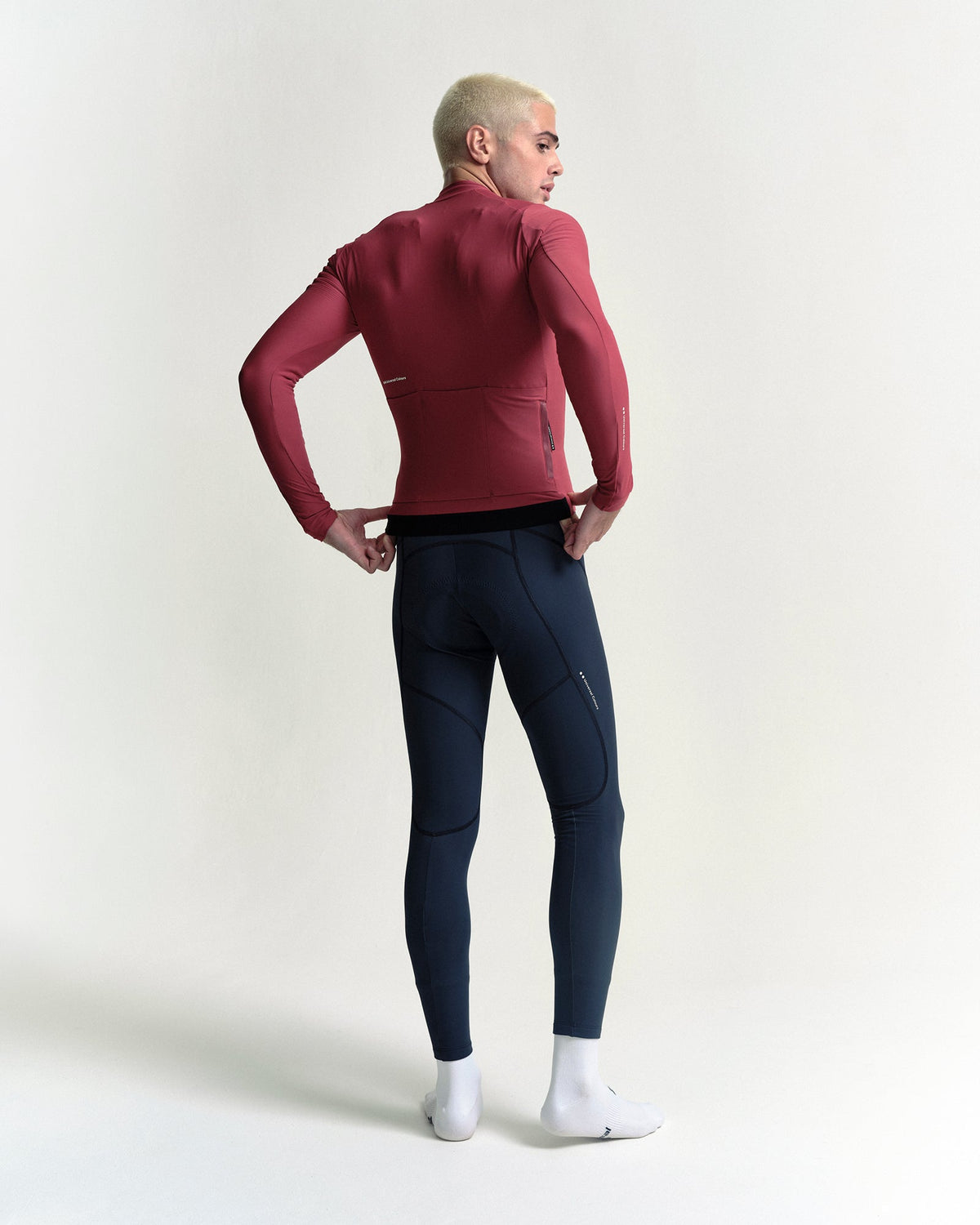 Model in the Men's Mono Long Sleeve Jersey in Apple Red, full-length back view.