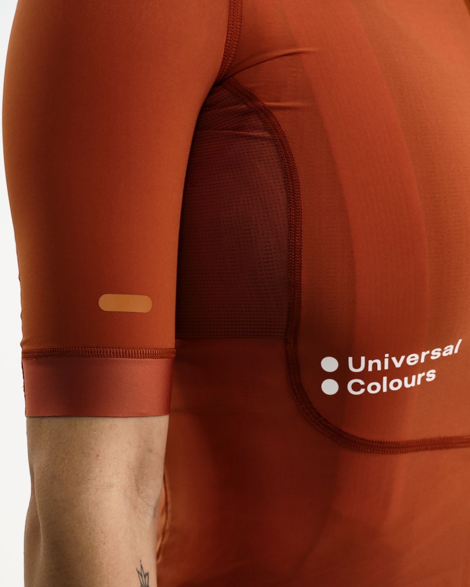 Moloko Cycling Ltd. women's short sleeve cycling jersey in Cyprus Copper. Made from recycled polyester with a matte finish and three rear pockets.