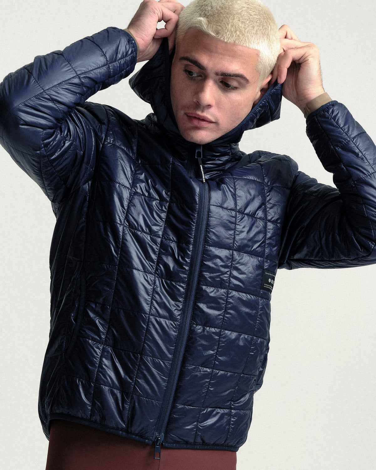 Model wearing the Unisex Insulated Packable Jacket in Ink Blue.