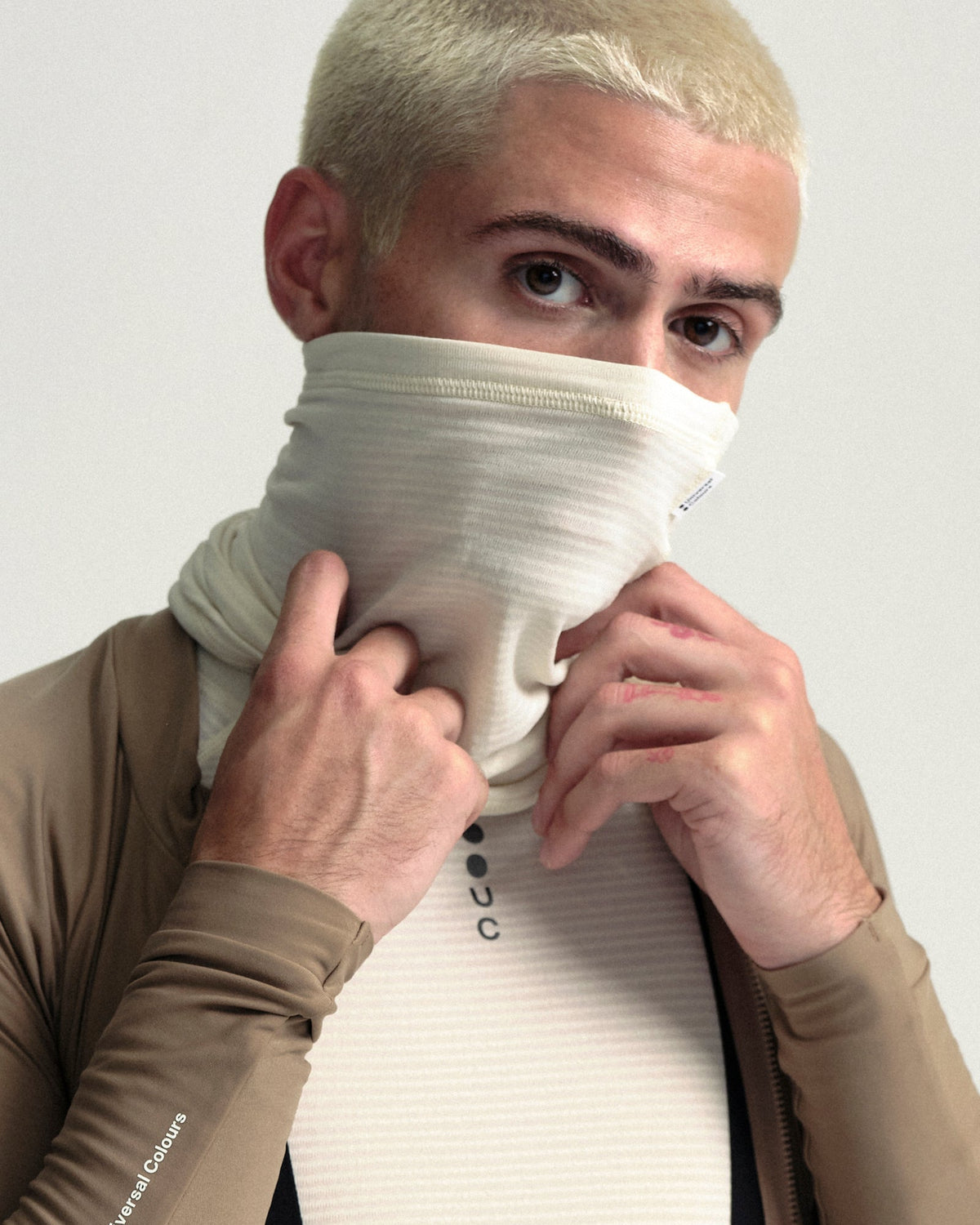 Model wearing the Polartec Neck Warmer in Off White.