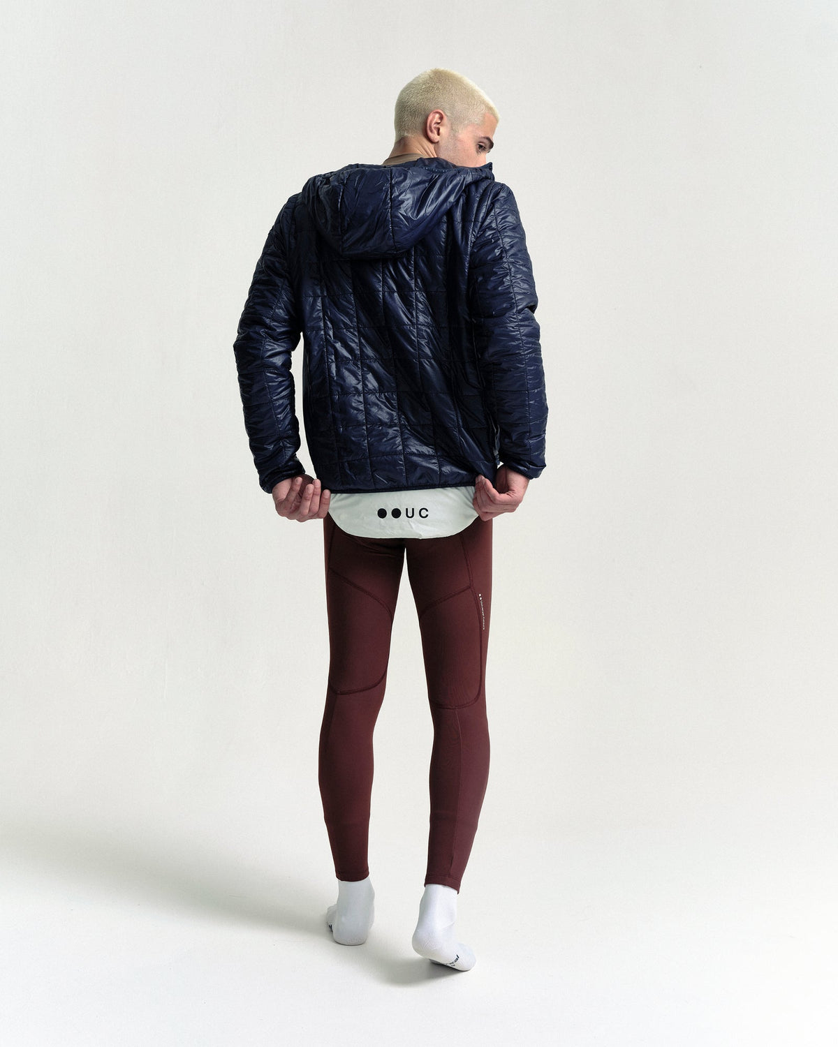 Model wearing the Unisex Insulated Packable Jacket in Ink Blue.
